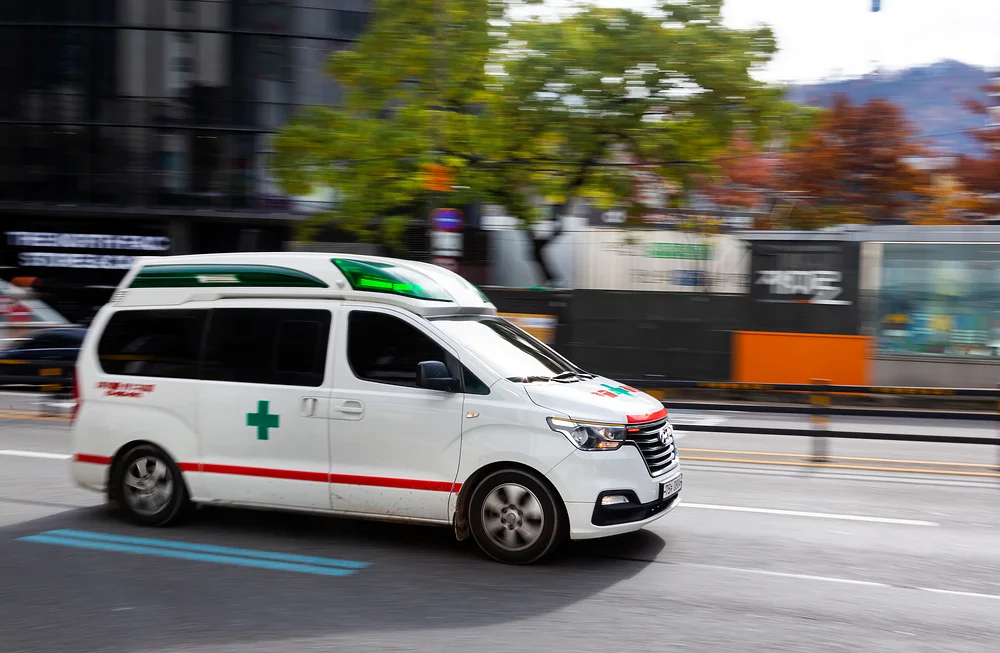 항암부작용병원|도로 위를 빠르게 주행 중인 구급차 사진